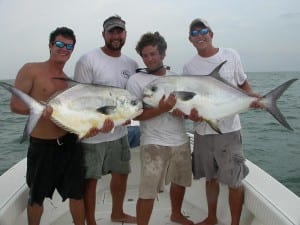 A happy group of clients on Tampa Permit fishing charter holding 2 large Permit.