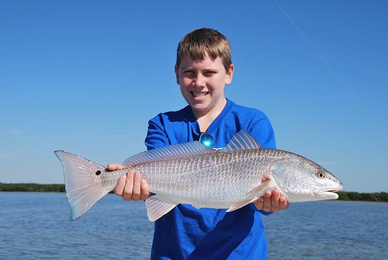 Tampa Bay fishing guide client olding large redfish during charter.